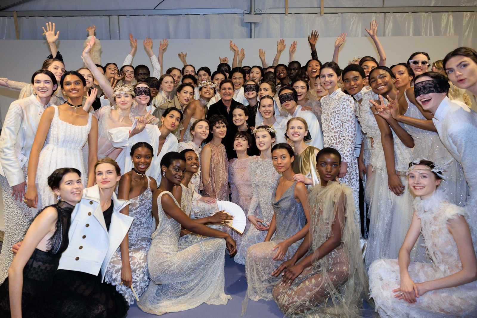 Maria Grazia Chiuri com modelos nos bastidores do desfile Dior Resort 2026.